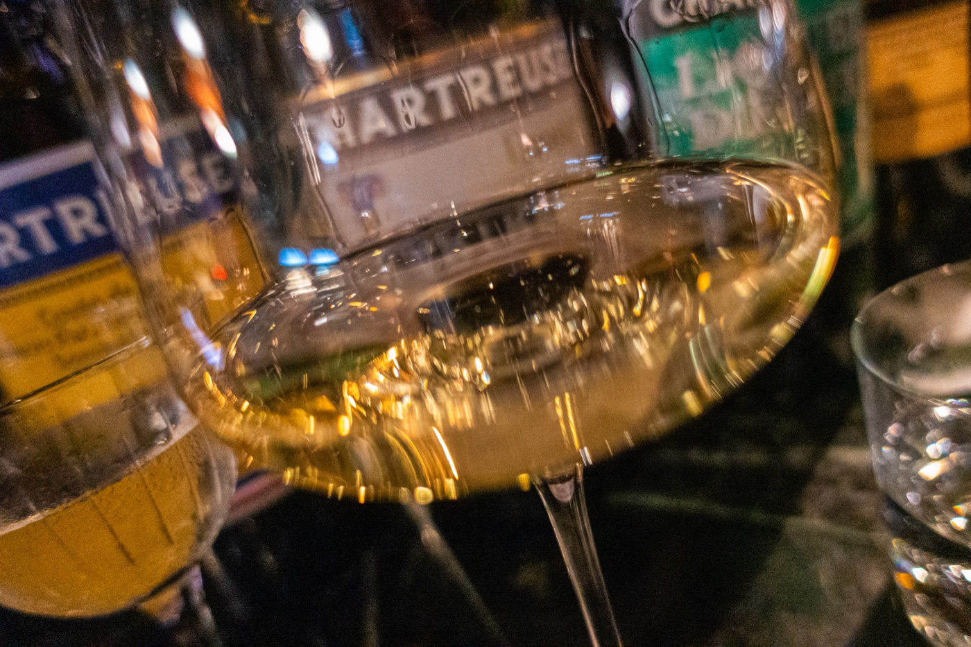 A glass of white wine at the bar, in front of the Chartreuse.